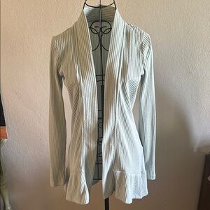 Elegant Light Blue Open-Front Sweater with Ruffle Bottom.